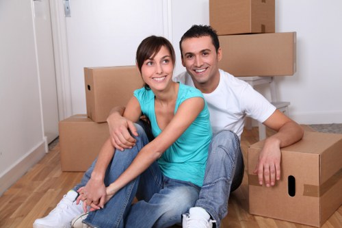 Professional movers carrying furniture through a Brompton property entrance